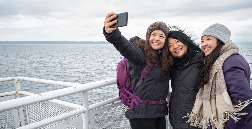 image of 3 young women taking a selfie on the bow of a boat